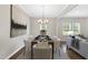 Modern dining area with stylish table setting, art, chandelier, and hardwood floors at 129 Explorer Dr # 256, Morrisville, NC 27560