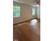 Bright bedroom featuring wood-look flooring, two windows and a ceiling fan at 1300 Seabrook Ave, Cary, NC 27511