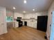 Bright kitchen features white cabinets, black appliances, hardwood floors, and recessed lighting at 1300 Seabrook Ave, Cary, NC 27511