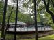 Community pool surrounded by a wrought iron fence, umbrellas, and lounge chairs for residents at 1300 Seabrook Ave, Cary, NC 27511
