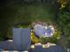 Aerial view of home's backyard highlighting the fire pit area, lush landscaping, and outdoor lighting at 1325 Mackinaw Dr, Wake Forest, NC 27587