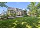 Backyard featuring a lush green lawn, screened porch, patio with grill and manicured landscaping at 1325 Mackinaw Dr, Wake Forest, NC 27587