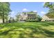 Spacious backyard featuring a lush green lawn, screened porch, patio with grill and manicured landscaping at 1325 Mackinaw Dr, Wake Forest, NC 27587