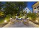 Backyard patio with stone fire pit and chairs, surrounded by mature trees and landscape lighting at 1325 Mackinaw Dr, Wake Forest, NC 27587