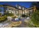 Patio featuring a stone fire pit, comfortable seating, and ambient lighting in the beautifully landscaped backyard at 1325 Mackinaw Dr, Wake Forest, NC 27587