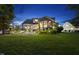 Backyard featuring a lush green lawn, screened porch, patio with grill and manicured landscaping at dusk at 1325 Mackinaw Dr, Wake Forest, NC 27587