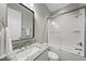 Modern bathroom showcasing a granite vanity, sleek fixtures, and a tiled shower-tub combo with glass door at 1325 Mackinaw Dr, Wake Forest, NC 27587