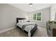 Serene bedroom featuring a comfortable bed, a side table with a lamp, and a window with a view of lush greenery at 1325 Mackinaw Dr, Wake Forest, NC 27587