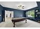 Spacious game room with pool table, built-in shelving, and large windows for natural light at 1325 Mackinaw Dr, Wake Forest, NC 27587