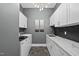 Well-equipped laundry room boasting new washer/dryer, white cabinets, ample counter space, and modern fixtures at 1325 Mackinaw Dr, Wake Forest, NC 27587