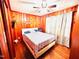 Cozy bedroom featuring wood paneled walls, a ceiling fan, and neutral bedding at 1337 Maple St, Rocky Mount, NC 27803