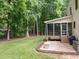 Spacious backyard with a screened porch, brick patio, lush lawn, and mature trees at 15 Smoketree Ct, Durham, NC 27712