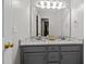 Bright bathroom with a double sink vanity, granite countertops, and a large mirror at 15 Smoketree Ct, Durham, NC 27712