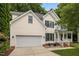 Charming two-story home with a two-car garage, blue shutters, front porch, and landscaped yard at 15 Smoketree Ct, Durham, NC 27712