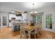 Eat-in kitchen featuring a chandelier over the table, white cabinets, granite countertops, and stainless steel appliances at 15 Smoketree Ct, Durham, NC 27712