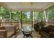 Cozy screened porch with wicker furniture, ceiling fan, and views of the backyard at 15 Smoketree Ct, Durham, NC 27712
