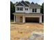 New construction home featuring light siding, a two-car garage, and a welcoming covered front porch at 161 Rollins Acres Ln, Lillington, NC 27546