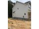 Exterior side view of a two story home with light siding and a concrete foundation at 161 Rollins Acres Ln, Lillington, NC 27546