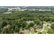 Neighborhood aerial view with tree coverage, lawns, surrounding commercial buildings, and highways at 1713 Elder Ct, Burlington, NC 27215