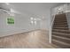 Bright basement featuring laminate flooring, stairs, and multiple windows at 1713 Elder Ct, Burlington, NC 27215