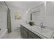 Bright bathroom featuring a double sink with modern fixtures, white tile, and a framed mirror at 1713 Elder Ct, Burlington, NC 27215