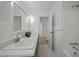 Clean bathroom featuring a double sink with modern fixtures, white tile, and a large framed mirror at 1713 Elder Ct, Burlington, NC 27215