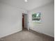 Bright bedroom featuring neutral carpet, a framed window with a view, and fresh white walls at 1713 Elder Ct, Burlington, NC 27215