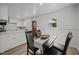 Cozy dining area with modern table and chairs, seamlessly flowing into the adjacent, bright white kitchen at 1713 Elder Ct, Burlington, NC 27215