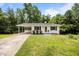 Well-maintained white brick home with green lawn, black shutters, and a covered carport at 1713 Elder Ct, Burlington, NC 27215