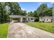 Charming white brick ranch-style home featuring a long driveway and mature trees at 1713 Elder Ct, Burlington, NC 27215