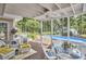 Relaxing covered back porch with wicker furniture and a view of the swimming pool at 1913 Fawndale Dr, Raleigh, NC 27612