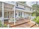 A charming back porch features white wicker furniture and a wooden deck, perfect for relaxation at 1913 Fawndale Dr, Raleigh, NC 27612