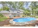 A spacious backyard features a sparkling pool, a wooden deck, and mature trees providing shade and privacy at 1913 Fawndale Dr, Raleigh, NC 27612