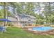 Expansive backyard featuring a swimming pool, wooden deck, a two-story home, and mature trees at 1913 Fawndale Dr, Raleigh, NC 27612
