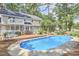 Serene backyard featuring a swimming pool, wooden deck, lush landscaping, and a charming two-story home at 1913 Fawndale Dr, Raleigh, NC 27612
