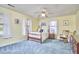Bright bedroom with yellow walls, blue carpet, and ceiling fan at 1913 Fawndale Dr, Raleigh, NC 27612