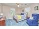 Cozy bedroom with blue carpet, wood furniture, ceiling fan, and bright natural light at 1913 Fawndale Dr, Raleigh, NC 27612