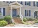 Welcoming entryway with a brick staircase, white railings, and charming blue shutters on the home at 1913 Fawndale Dr, Raleigh, NC 27612