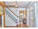 Inviting foyer featuring a staircase with blue carpet, hardwood floors, and a charming chandelier at 1913 Fawndale Dr, Raleigh, NC 27612