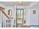 Bright foyer featuring a wooden staircase, tiled floor, and a glimpse of the outdoors through the front door at 1913 Fawndale Dr, Raleigh, NC 27612