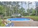Inviting pool area with a wooden deck, lush plants, and a nearby seating area, ideal for relaxation at 1913 Fawndale Dr, Raleigh, NC 27612