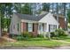 Side view of charming Cape Cod-style home featuring a brick and siding facade, complemented by lush greenery at 213 Bracken Ct, Raleigh, NC 27615