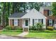 Charming Cape Cod-style home featuring a brick and siding facade, complemented by lush greenery and a welcoming front porch at 213 Bracken Ct, Raleigh, NC 27615