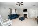 Inviting living room with a fireplace, ceiling fan, and a comfortable blue couch and ottoman at 213 Bracken Ct, Raleigh, NC 27615