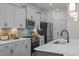 Modern kitchen featuring gray cabinetry, stainless steel appliances, and a stylish backsplash, perfect for cooking and entertaining at 215 Faith Avenue, Sanford, NC 27330