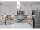 Modern kitchen with stainless steel appliances, gray cabinets, and a spacious quartz countertop at 215 Faith Avenue, Sanford, NC 27330
