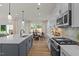 Open kitchen with island, gray cabinets, breakfast nook, stainless appliances, stone backsplash and lots of light at 215 Faith Avenue, Sanford, NC 27330