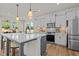 Bright kitchen with stainless appliances, gray cabinets, kitchen island, and breakfast nook bathed in natural light from large windows at 215 Faith Avenue, Sanford, NC 27330