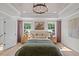 A spacious main bedroom with a decorative tray ceiling, wood floors, and warm color palette at 215 Faith Avenue, Sanford, NC 27330