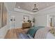 A view of the main bedroom with wood floors, tray ceiling, and a light color palette at 215 Faith Avenue, Sanford, NC 27330